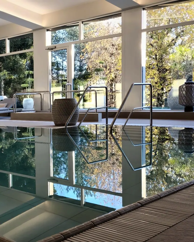 Des marches larges et des mains courantes en inox descendent dans l’eau de la piscine thérapeutique